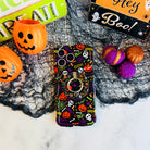 Spooky MagSafe grip ring attached to the matching Wavy Luxe case on black spiderweb mesh with an orange pail and a Hey Boo sign.