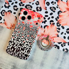 Flower-fetti Leopard pattern MagSafe phone grip ring with pink and orange flowers over black and white leopard spots compatible with iPhone and Samsung