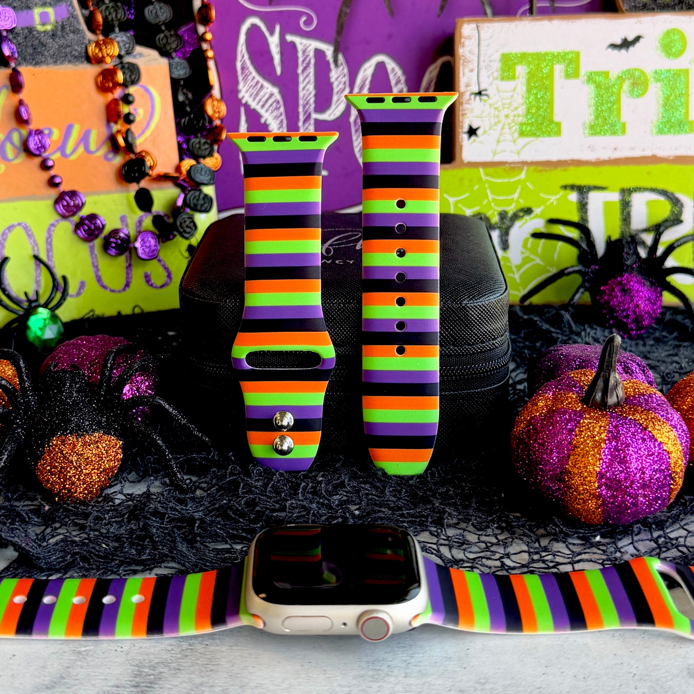 Main Witch Energy silicone Apple Watch band hero shot, black, purple, green and orange stripes, shown with a rose gold Apple Watch.
