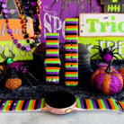 Main Witch Energy silicone Samsung Galaxy Watch band hero shot in black, purple, green and orange stripes, shown with a rose gold Galaxy Watch.