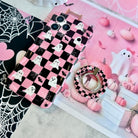 The Hey Boo, Looking Cute MagSafe grip ring beside the matching pink and black checkerboard ghost iPhone case on a white spiderweb backdrop.
