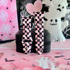 Hey Boo, Looking Cute Apple Watch band shown in both size options on a black stand, pink and black checkerboard ghost print.
