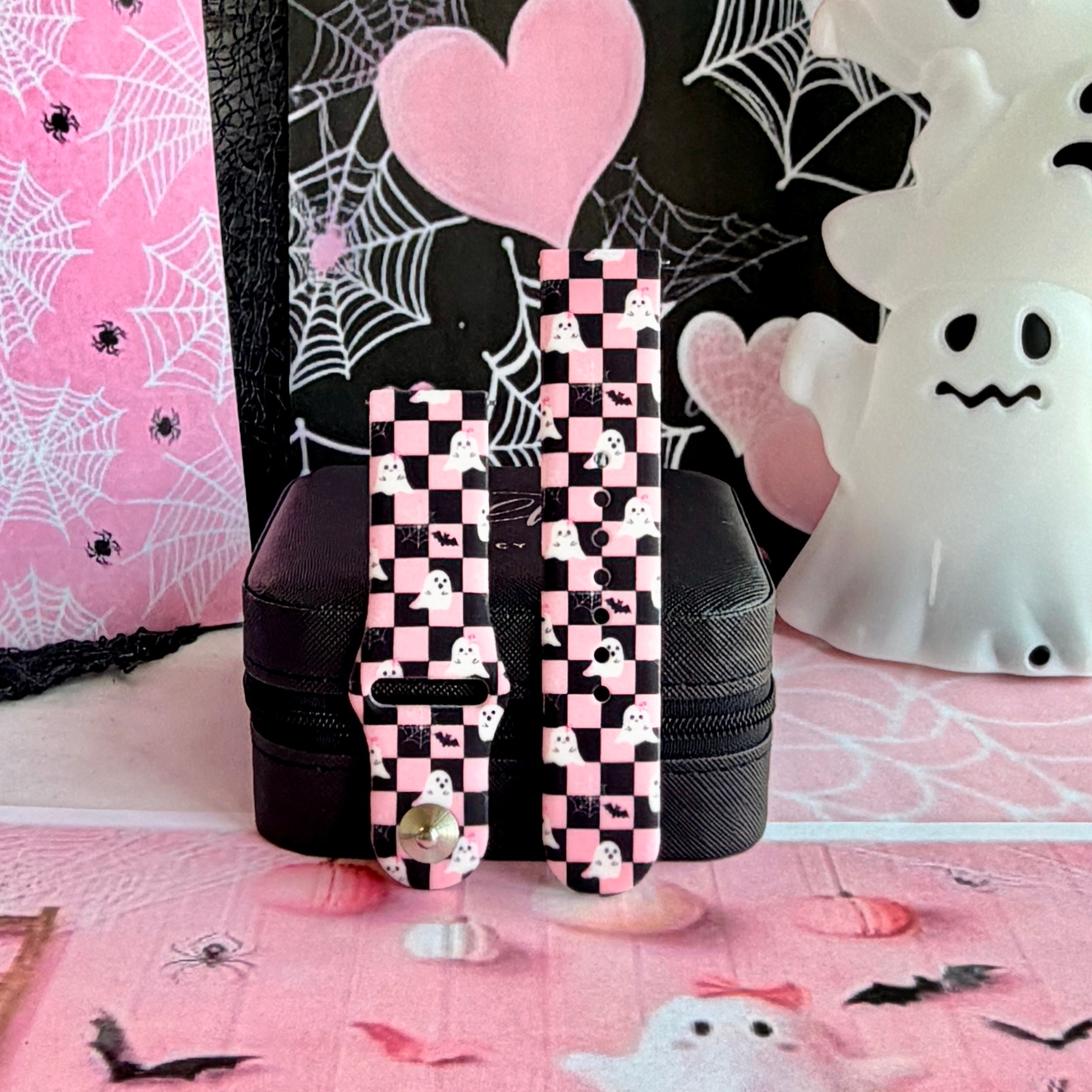 Hey Boo, Looking Cute Samsung Galaxy Watch band shown in both size options on a black stand, pink and black checkerboard ghost print.
