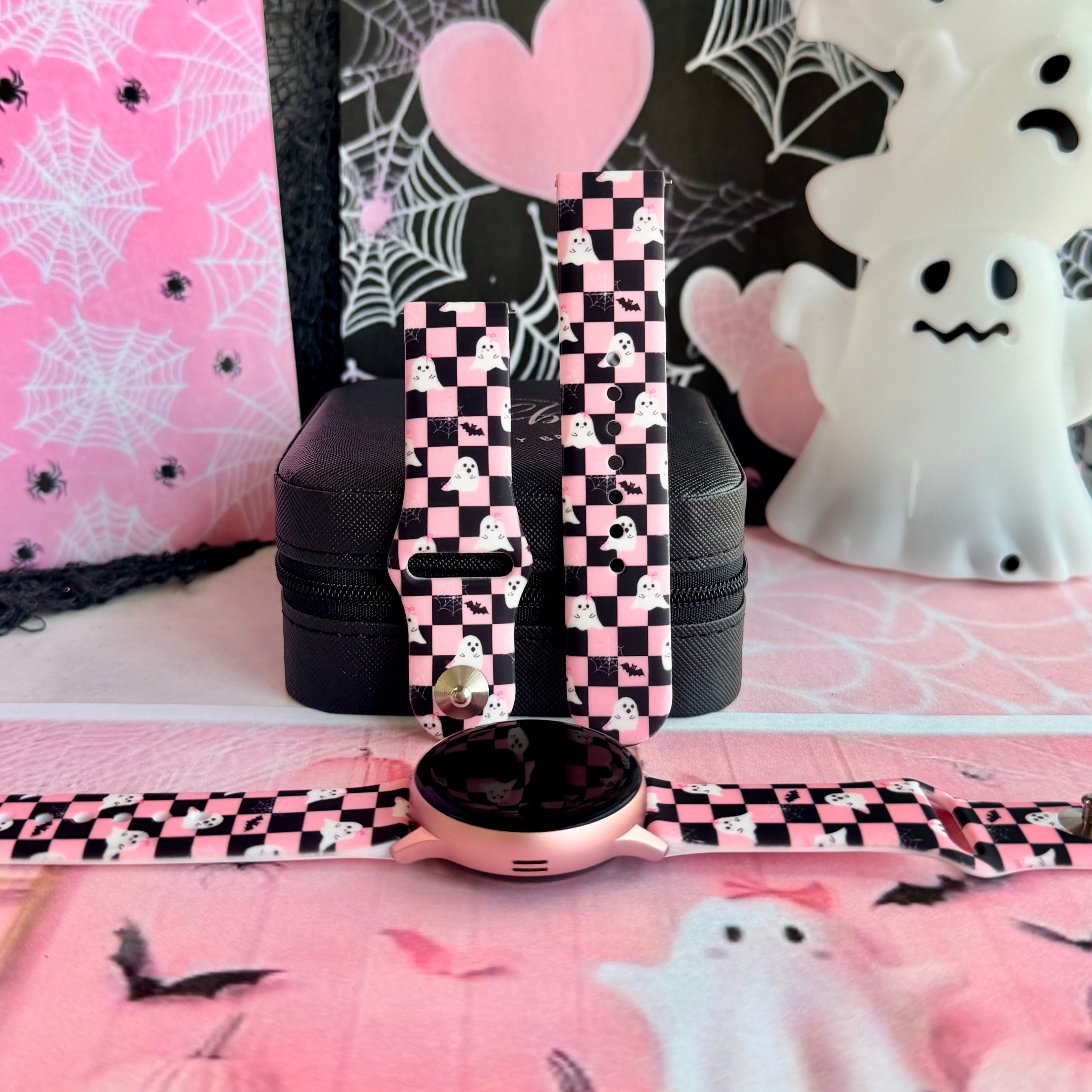 Hey Boo, Looking Cute silicone Samsung Galaxy Watch band standing upright with a round Samsung watch at its base, pink and black checkerboard with white ghosts.