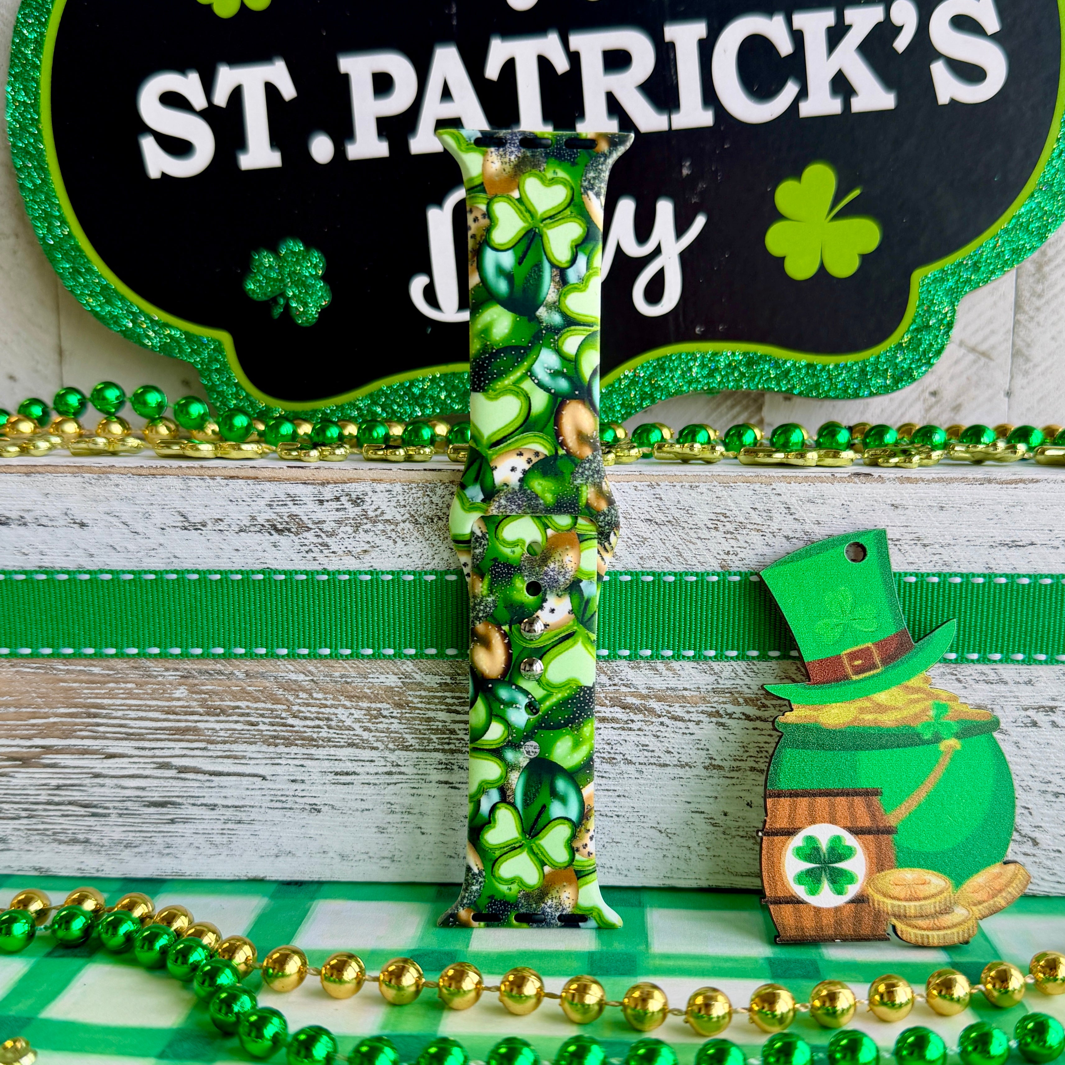 St. Patrick's Day Apple Watch band with green shamrocks, gold coins, and leprechaun hats on festive display
