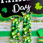 St. Patrick's Day Apple Watch band with green shamrocks, gold coins, and leprechaun hats on festive display
