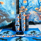 The Bewitching Hour silicone Apple Watch band shown in both sizes with an Apple Watch at the base, light blue with jack-o-lanterns, owls and crescent moons.