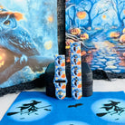 The Bewitching Hour Samsung Galaxy Watch band displayed beside a painted owl backdrop, light blue silicone with witch hats and jack-o-lanterns.