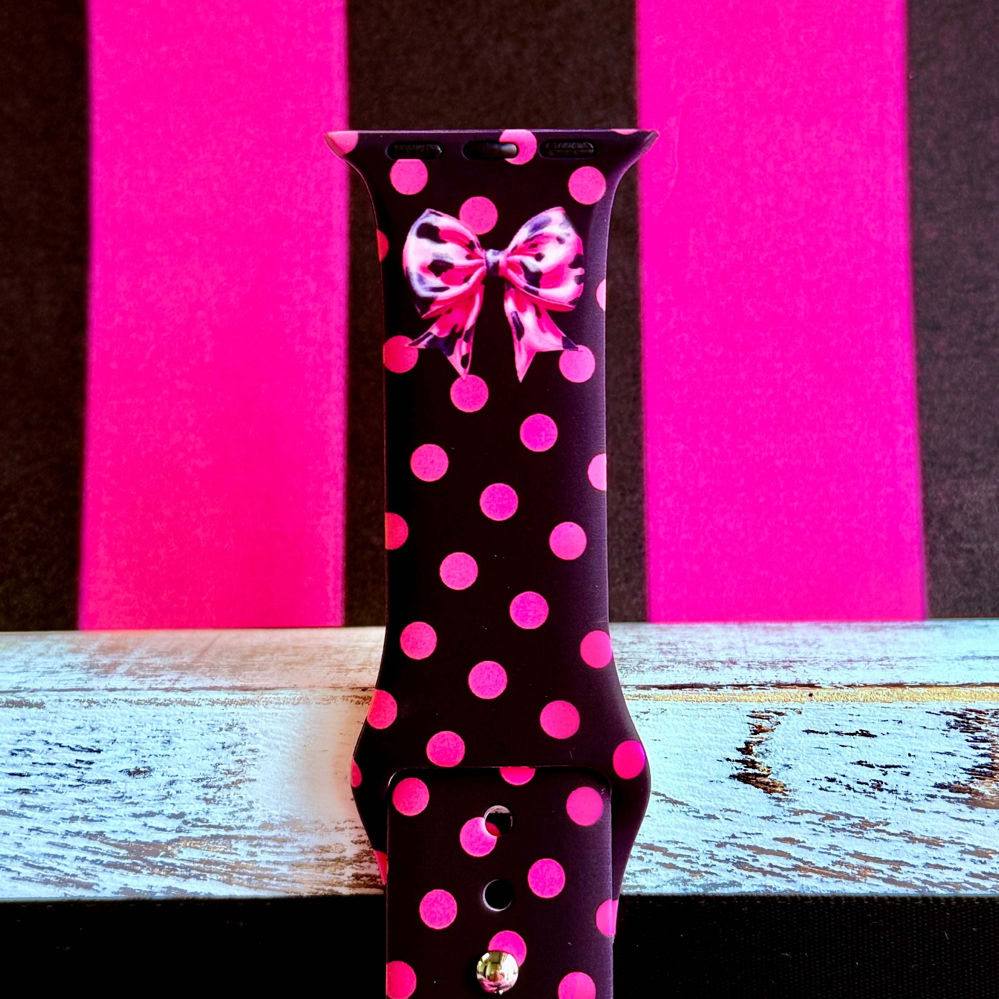 Sweet Spot Apple Watch band with pink polka dots and bow accents on black background with striped backdrop
