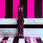 Sweet Spot Apple Watch band with pink polka dots and bow accents on black background with striped backdrop

