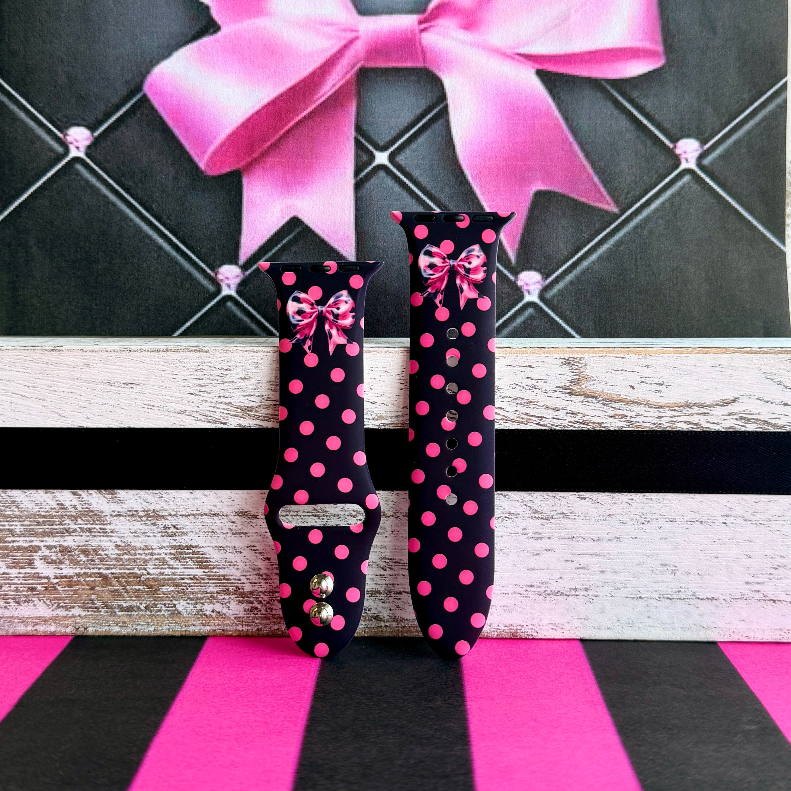 Sweet Spot Apple Watch band with pink polka dots and bow accents on black background with striped backdrop
