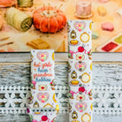 It's Giving Grandma Hobbies silicone Samsung Galaxy Watch band with "hot girls have grandma hobbies" script, patchwork hearts, yarn balls, knitting needles, embroidery hoops, lanterns, pies, and teacups on a cream base, shown displayed and worn against a cottagecore craft backdrop.