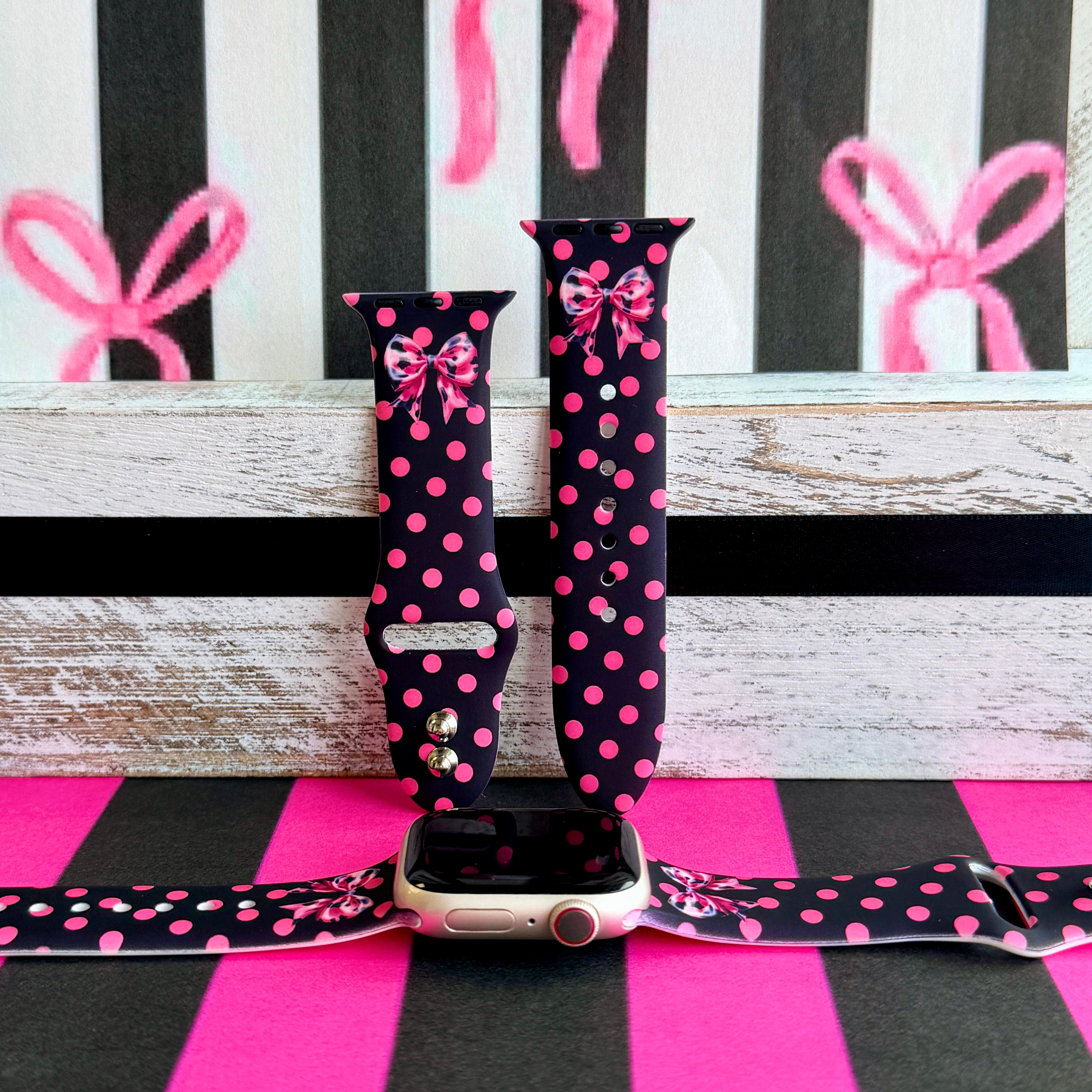 Sweet Spot Apple Watch band with pink polka dots and bow accents on black background with striped backdrop
