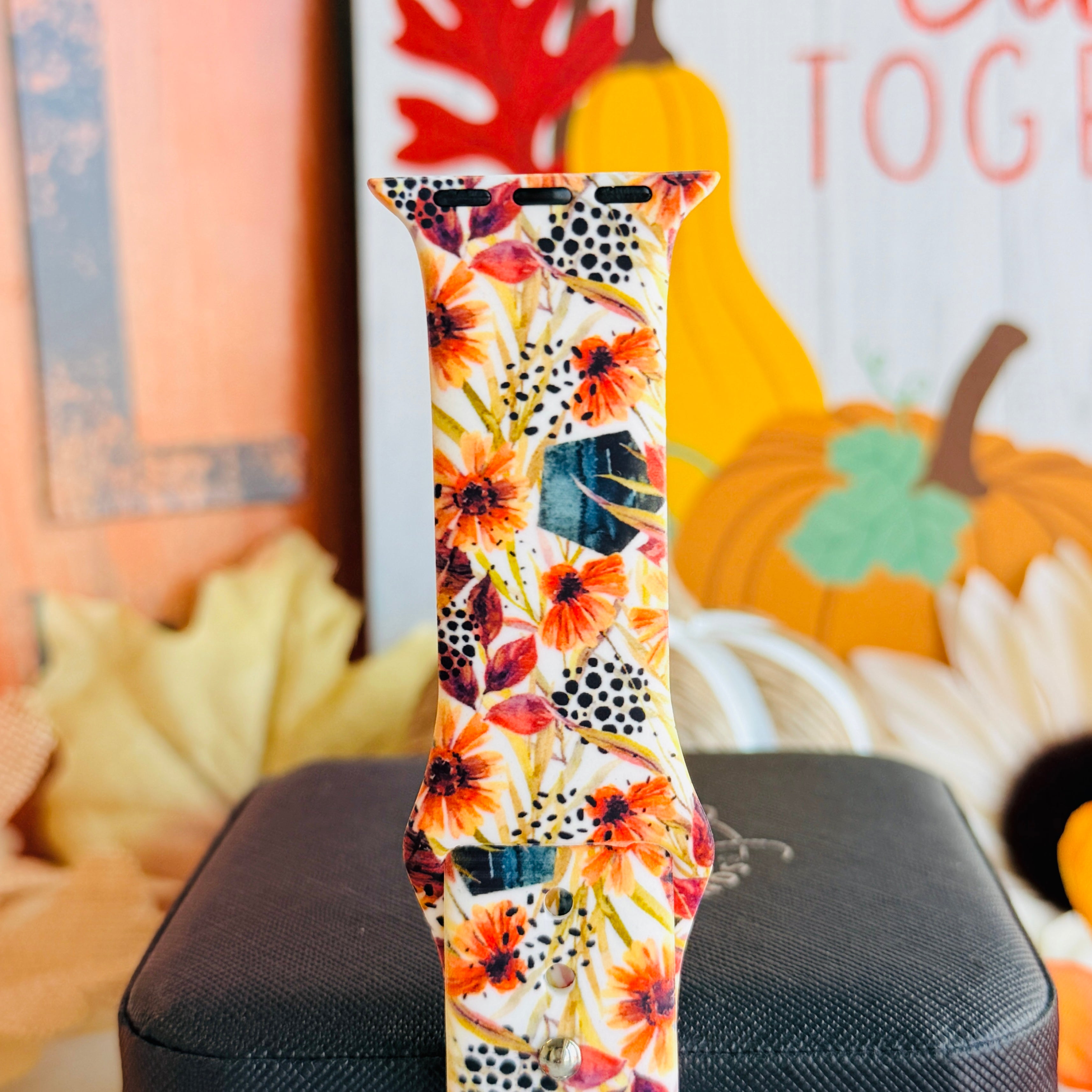 Close view of the Sienna Petals Apple Watch band showing the burnt orange and sienna watercolor blooms on a cream ground.