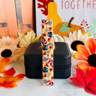 Sienna Petals Samsung Galaxy Watch band standing full length in front of a Gather Together fall sign with pumpkins and sunflowers.