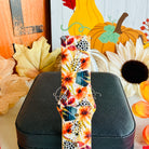 Close view of the Sienna Petals Samsung Galaxy Watch band showing the sienna and orange watercolor blooms with deep teal foliage on cream silicone.