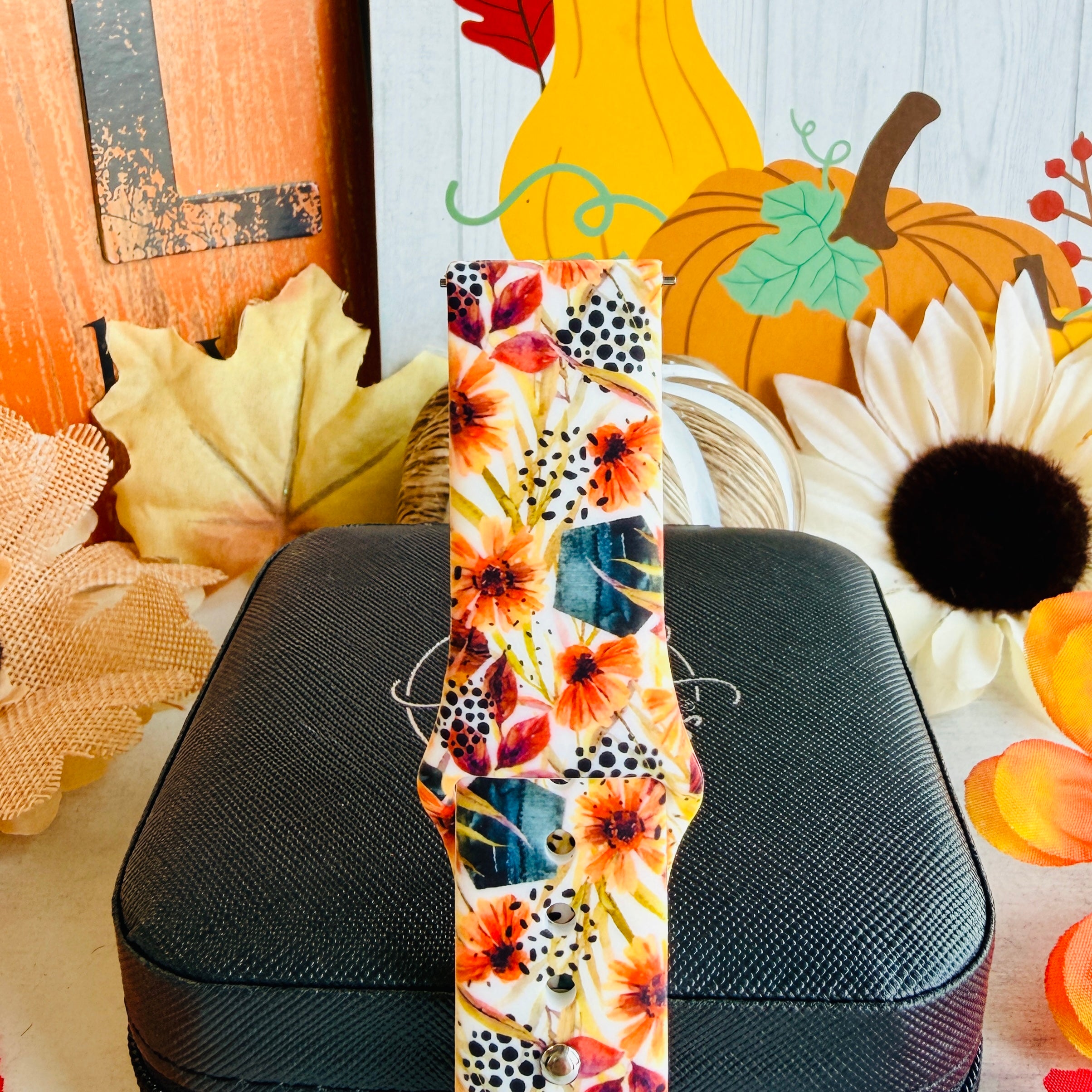 Close view of the Sienna Petals Samsung Galaxy Watch band showing the sienna and orange watercolor blooms with deep teal foliage on cream silicone.