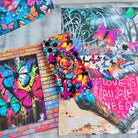 Trendy wavy iPhone case featuring a vibrant street-art collage of electric blue and yellow butterflies over neon pink paint splatters with a high-gloss finish.