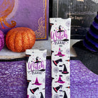 Witch Please Fitbit Versa 3/4 and Sense band standing upright beside an orange glitter pumpkin with the Witch Please script visible.