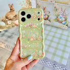 Sage green wavy iPhone case featuring a vintage watercolor pattern of bunnies, Easter eggs, and spring flowers.