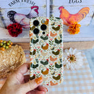 Hand holding the Cluckin' Cute Wavy Luxe MagSafe iPhone case with speckled hens and wildflowers on a farmhouse background