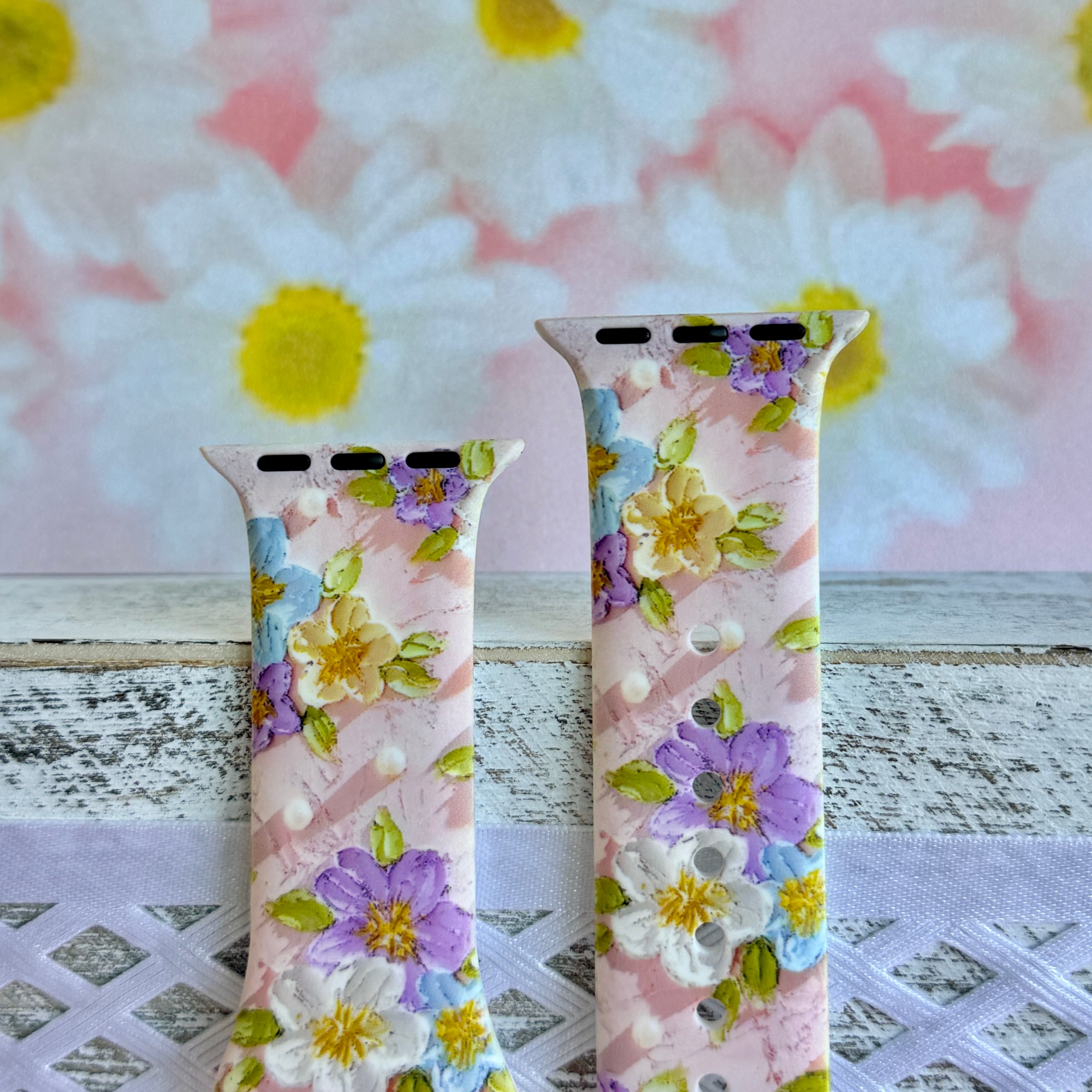 Blushing Bouquet Apple Watch band with watercolor flowers in purple, blue, yellow, and white on soft pink background
