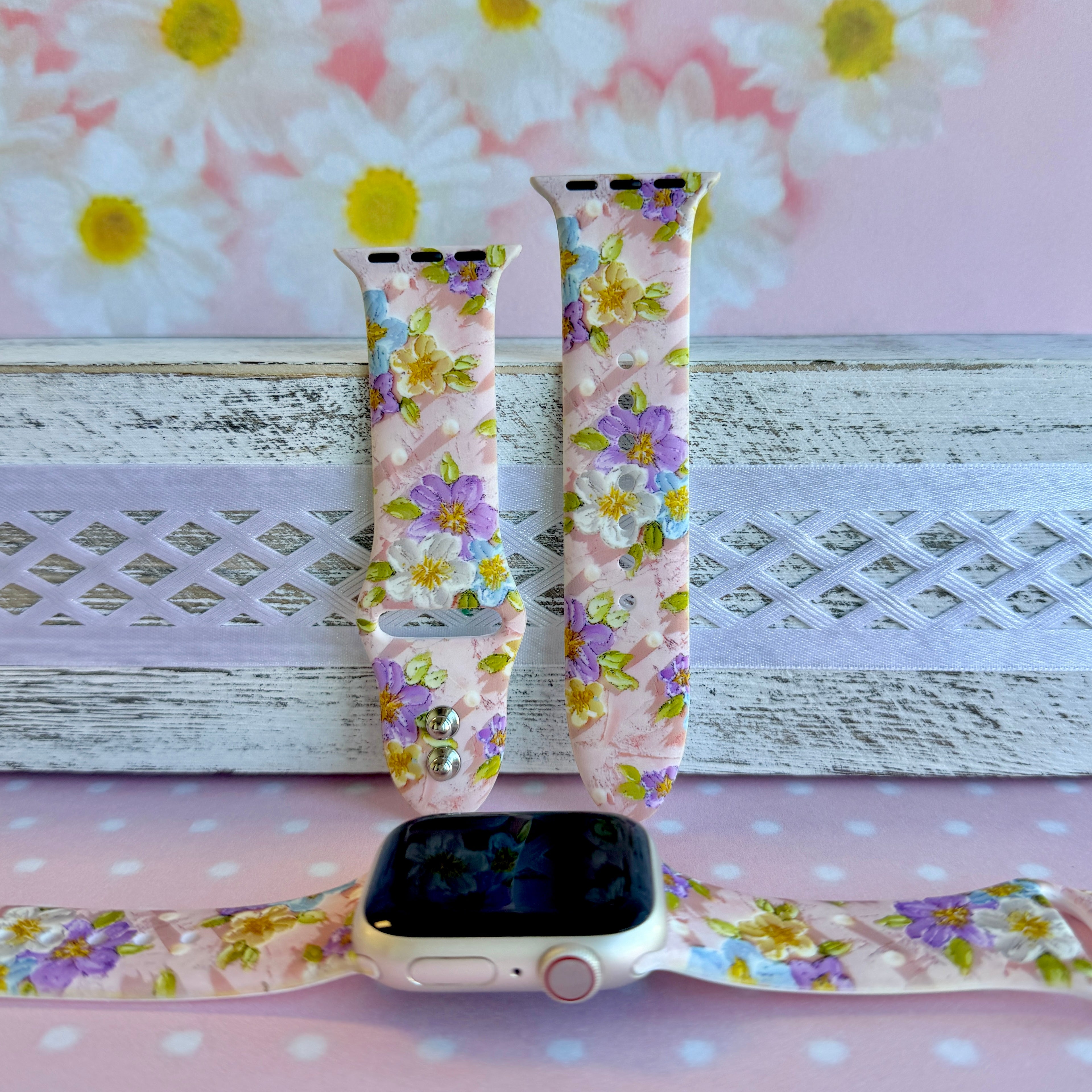 Blushing Bouquet Apple Watch band with watercolor flowers in purple, blue, yellow, and white on soft pink background
