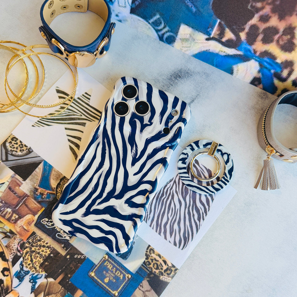 Zebra, Obviously navy zebra print MagSafe grip ring shown beside the matching zebra iPhone case on an animal-print fashion flat lay with a tassel keyring and gold hoops.