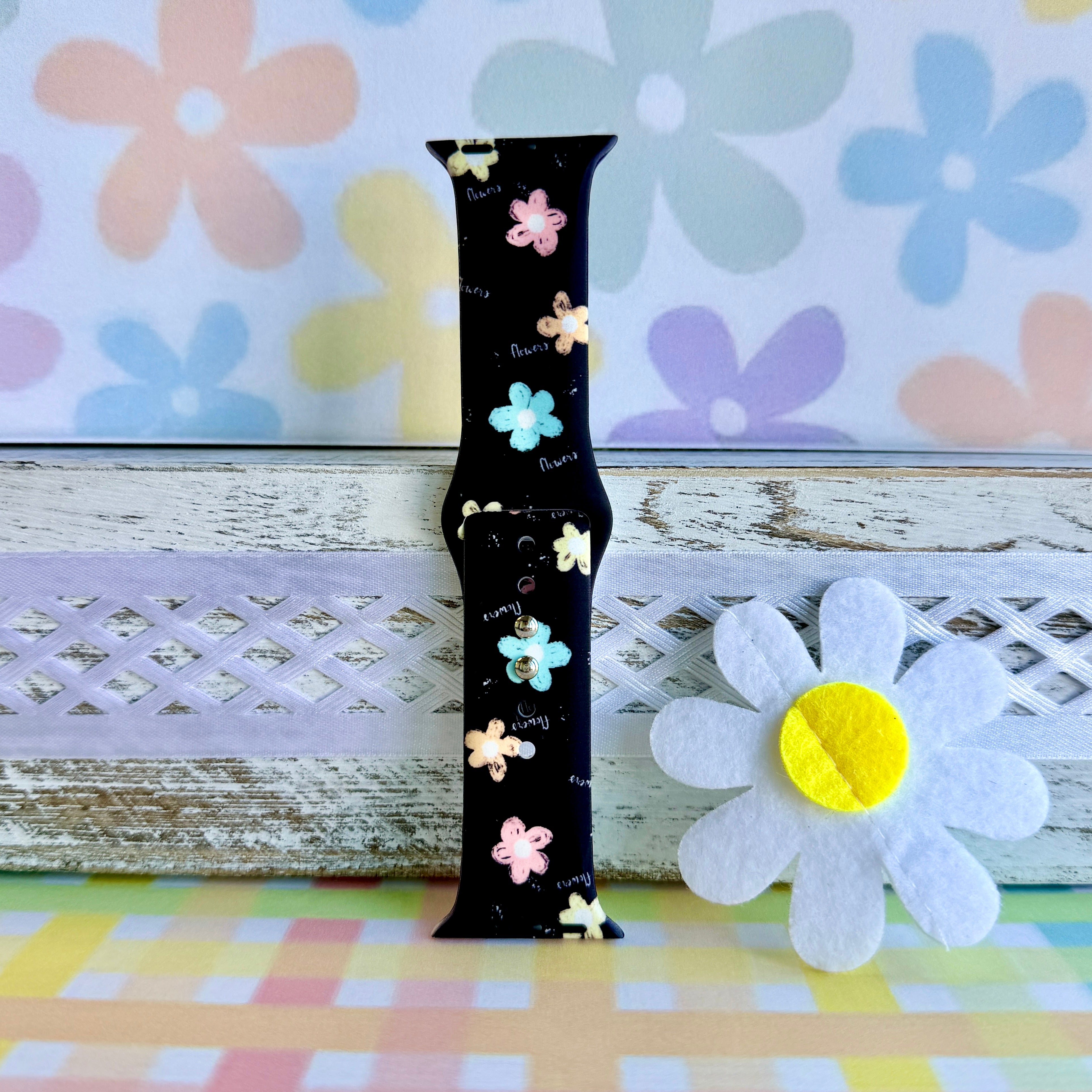 Flower Pop Apple Watch band with pastel flowers in pink, yellow, turquoise, and peach on black background with daisy decorations
