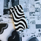 Wavy iPhone case featuring a bold black and white swirly striped pattern with a high-gloss finish.