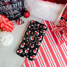 Snowman iPhone case with the matching MagSafe grip ring attached, on candy cane stripes with a Santa hat and ornaments