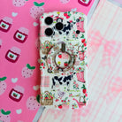Farm Girl Cutie cottagecore MagSafe phone grip ring with pink watering cans, strawberries, rain boots, and gingham patterns on an off-white background compatible with iPhone and Samsung