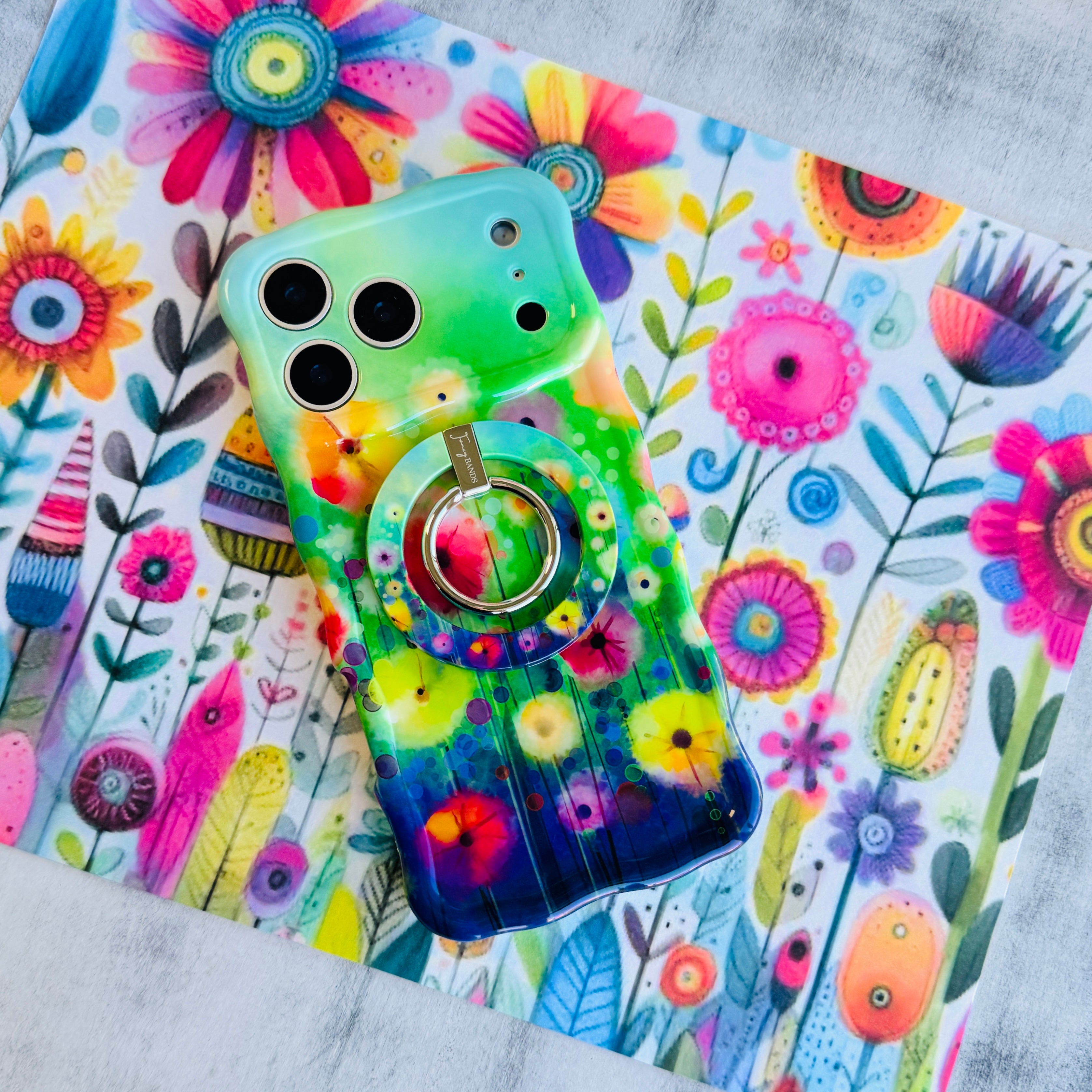 Petal Princess watercolor floral MagSafe phone grip ring with vibrant pink and yellow blooms on green background compatible with iPhone and Samsung