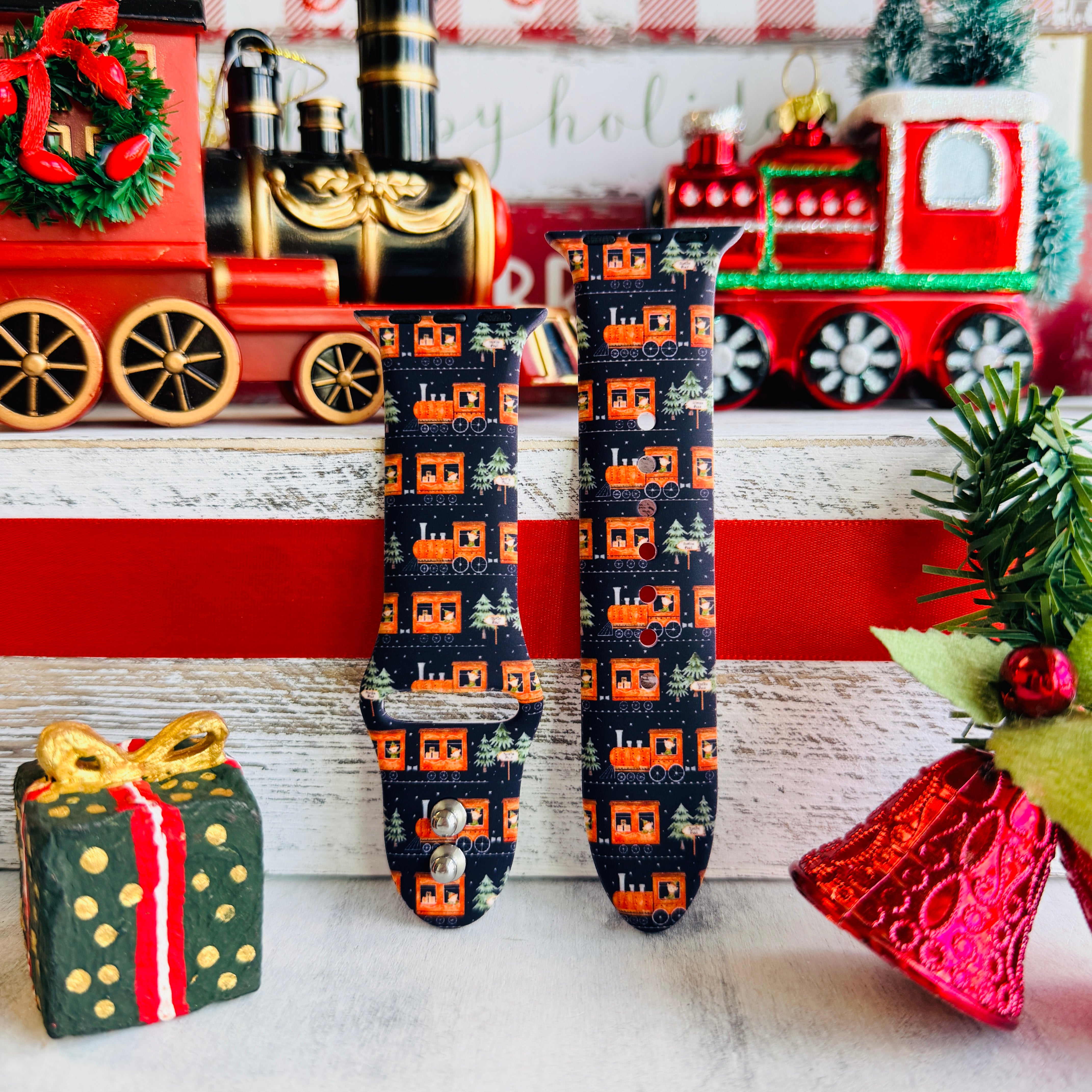 Apple Watch with Jolly Trolly train pattern band next to holiday decorations