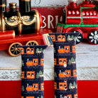 Two phone cases with train design in front of toy trains on a wooden surface.