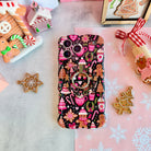 Merry Mugs and Ginger Hugs Hold It Fancy MagSafe grip ring attached to the matching gingerbread iPhone case, with gingerbread cookies and a gingerbread house