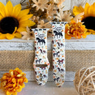 Two watch straps with horse designs on a decorative background with sunflowers and burlap.