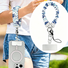 A Blue Lagoon scrunchie phone wrist strap with a blue and white sea turtle and ocean design attached to a matching Wavy Luxe case on a blue starfish background.