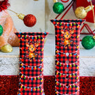 Close-up of Deerlightful reindeer print with festive lights on red and black buffalo check Apple Watch silicone band
