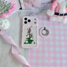 Pretty in PinkMas pink striped MagSafe grip ring beside the matching iPhone case, with pink gingham ribbon and a pink Santa coat