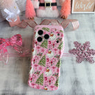 Pink floral phone case on a decorative surface with ribbons and snowflake decorations.