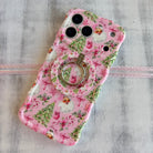 Pink floral phone case with a ring holder on a gray background