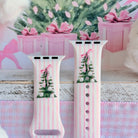 Both straps of the Pretty in PinkMas silicone Apple Watch band standing up, each with a watercolor Christmas tree and pink bow