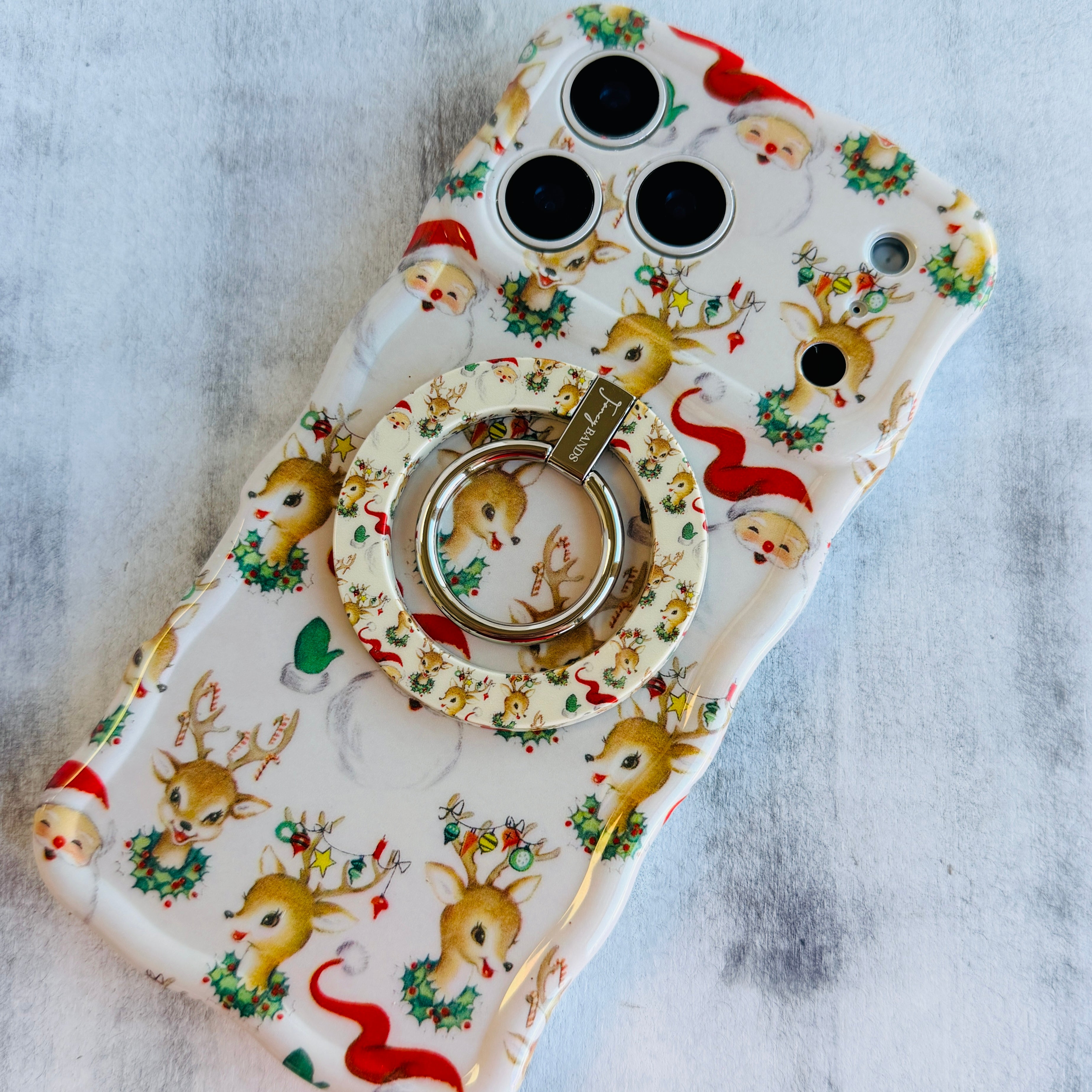 Phone case with Christmas design featuring reindeer and Santa Claus on a light gray background