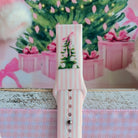 Close-up of the Pretty in PinkMas Samsung watch band print: a Christmas tree with a pink ribbon bow on pink stripes
