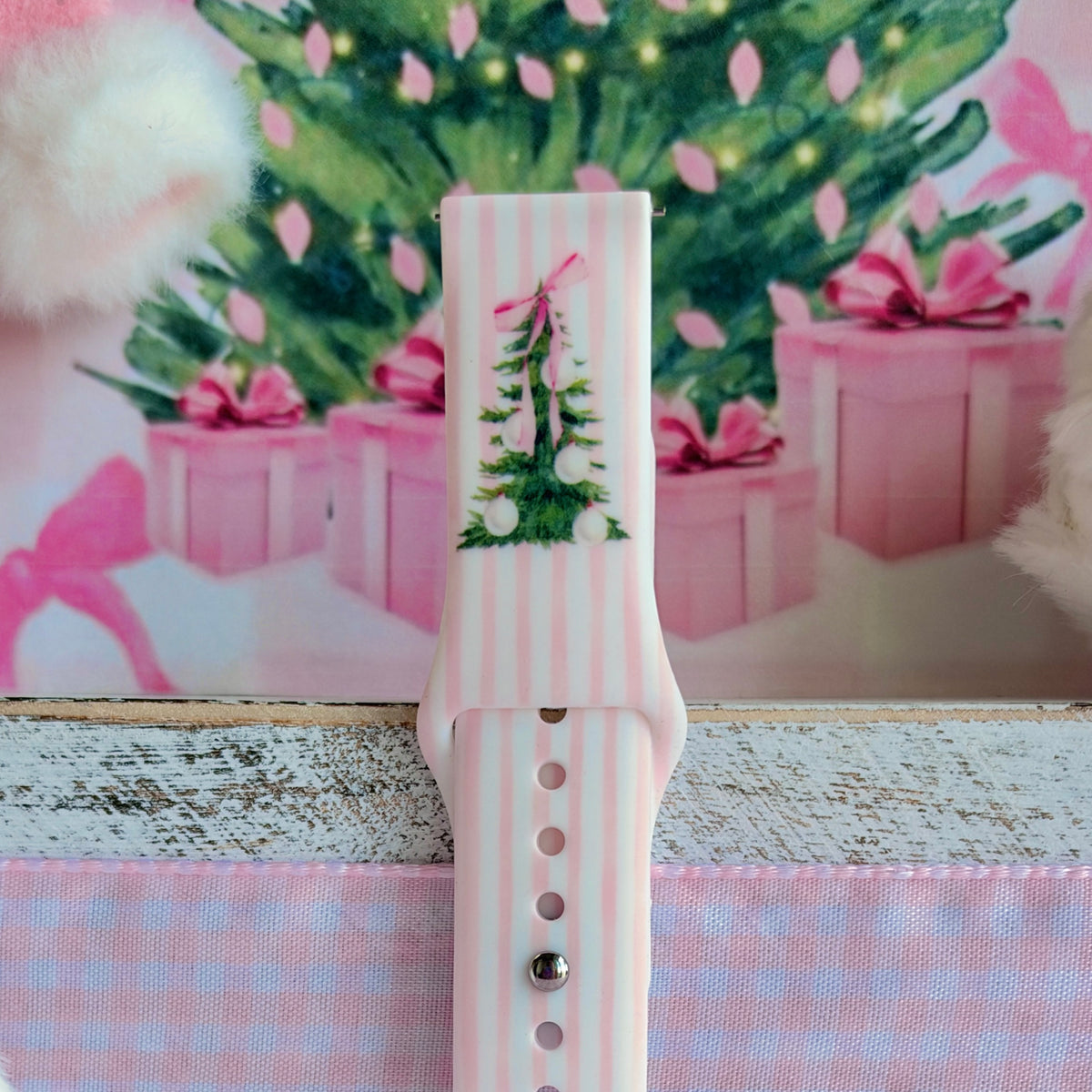 Close-up of the Pretty in PinkMas Samsung watch band print: a Christmas tree with a pink ribbon bow on pink stripes