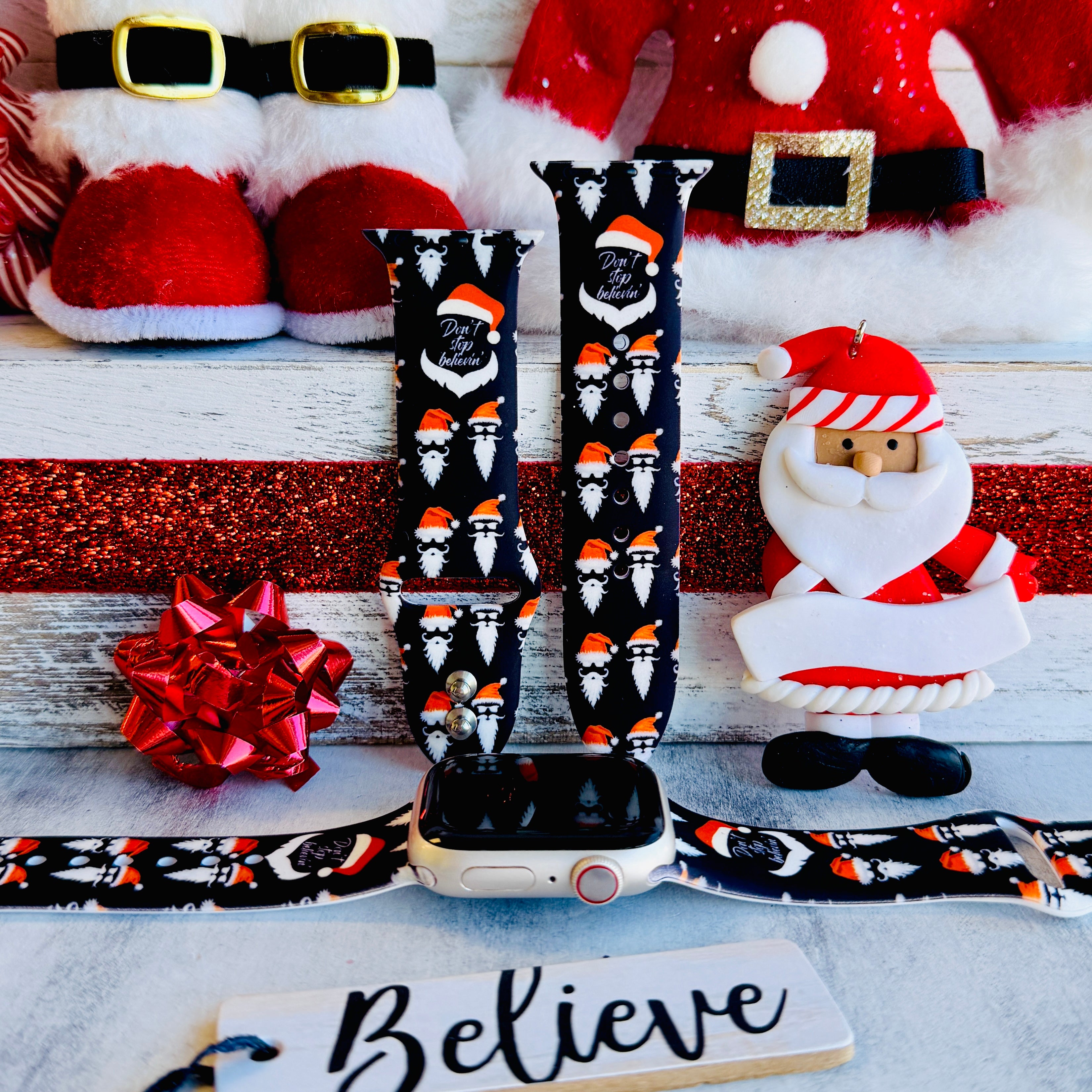 Don't Stop Believin' Apple Watch band with Santa beards and red hats on black background with Christmas decorations

