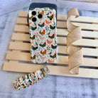 Cluckin' Cute scrunchie phone wrist strap clipped to the matching Cluckin' Cute Wavy Luxe iPhone case