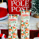 Close-up of North Pole village scene with vintage typography, elves, and festive cottages on Apple Watch silicone band
