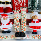 North Pole Apple Watch band with Santa's workshop, Christmas trees, and reindeer on cream background with North Pole sign
